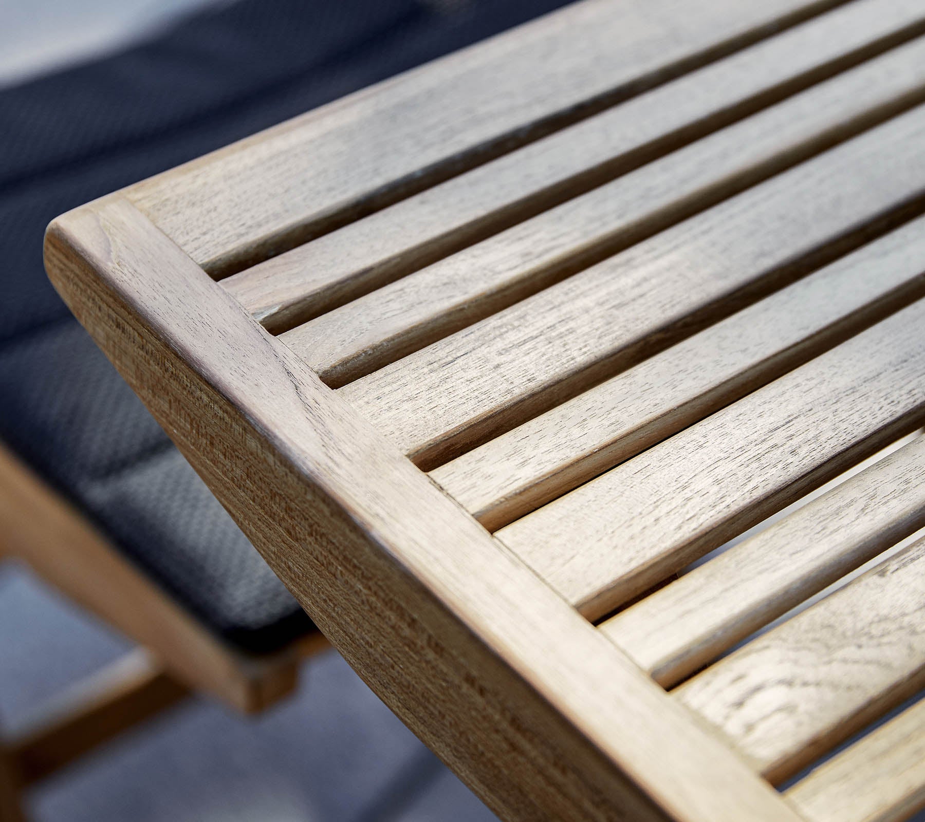 Nahaufnahme einer Holzstirnkante mit lamellenförmigem Design, die die natürliche Maserung und Textur des Holzes zeigt.