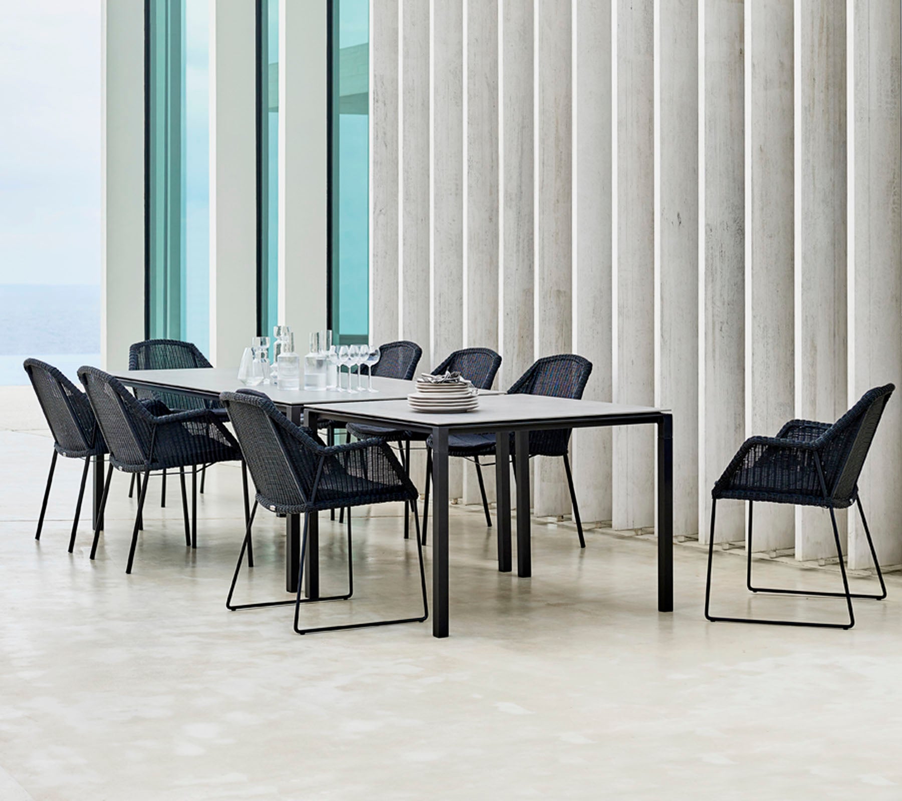 Ein modernes Esszimmer-Set mit schwarzen Stühlen, die darum herum angeordnet sind, mit minimalistischen Designelementen und einer eleganten Tischdekoration.