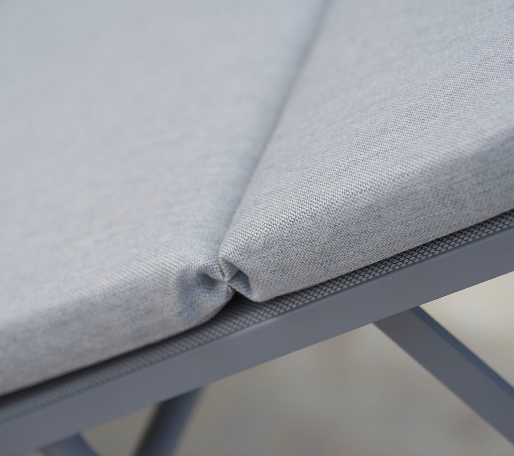 Grau gepolsterter Sitzstoff mit ordentlicher Naht, der ein nahtloses Design und eine langlebige Stützstruktur präsentiert.