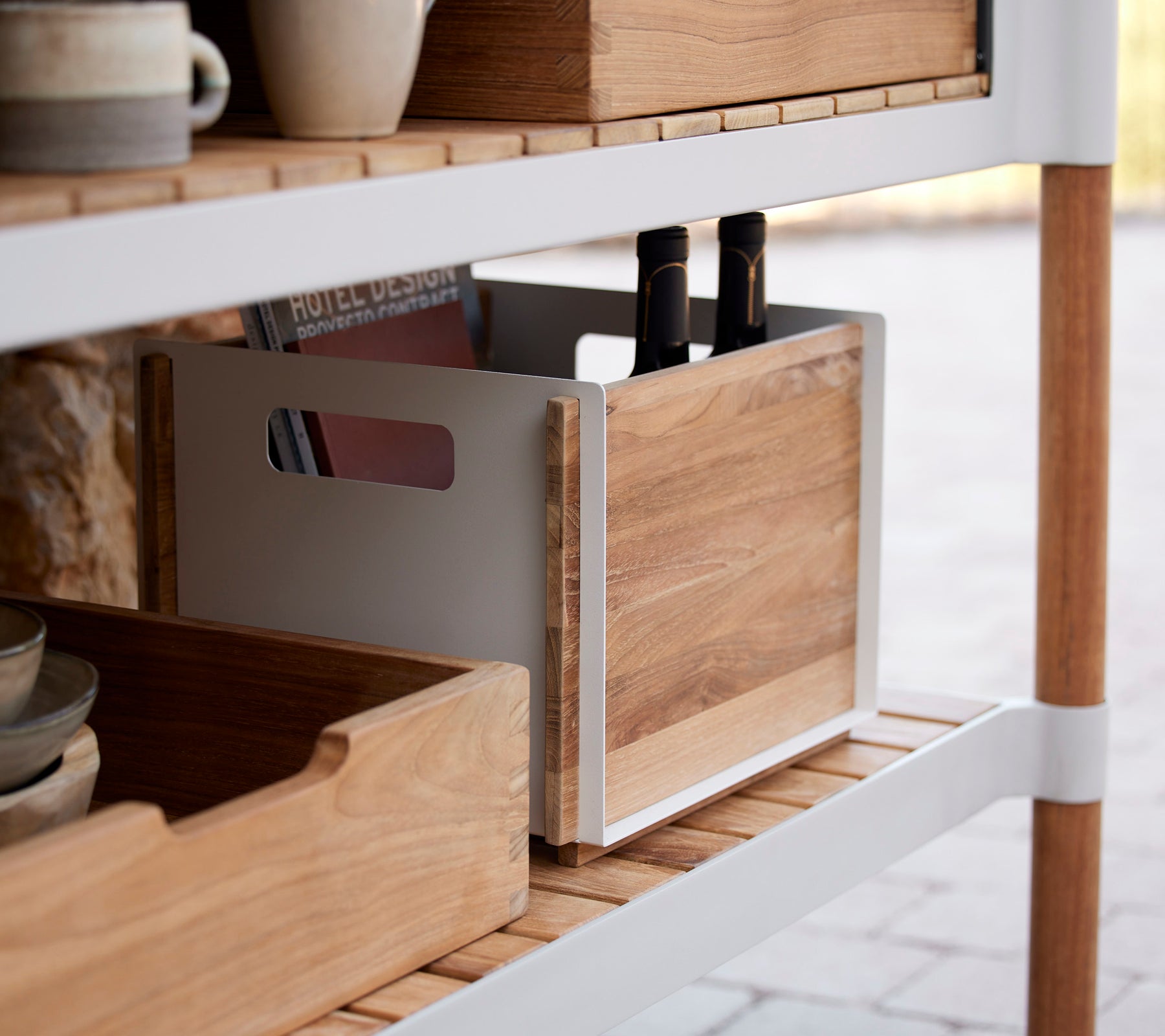 Holzkisten auf einem Regal, eine mit Küchenutensilien darin, mit minimalistischen Design und natürlichen Oberflächen.