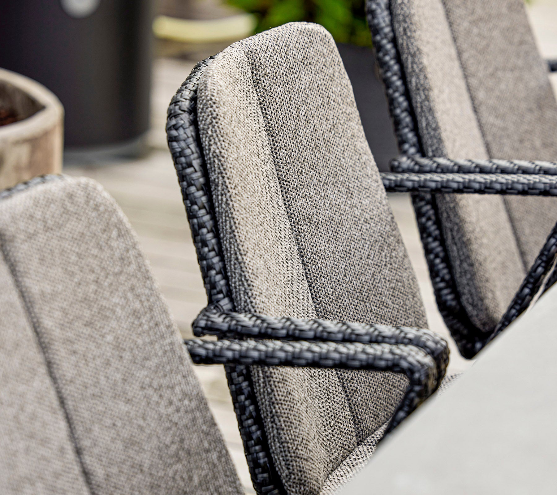 Nahaufnahme von stilvollen Stühlen mit strukturiertem Stoff und eleganten Seilakzenten, geeignet für modernes Outdoor-Sitzen.