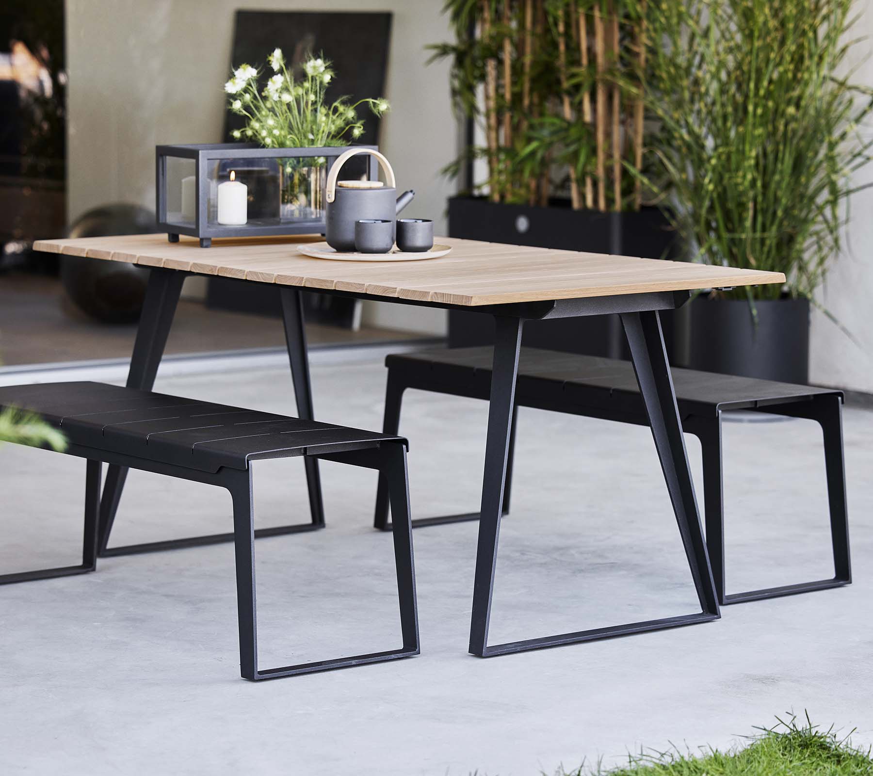Stylischer Tisch in Kopenhagen, kombiniert mit passenden Bänken, mit modernem Design und minimalistischen Dekorationselementen.