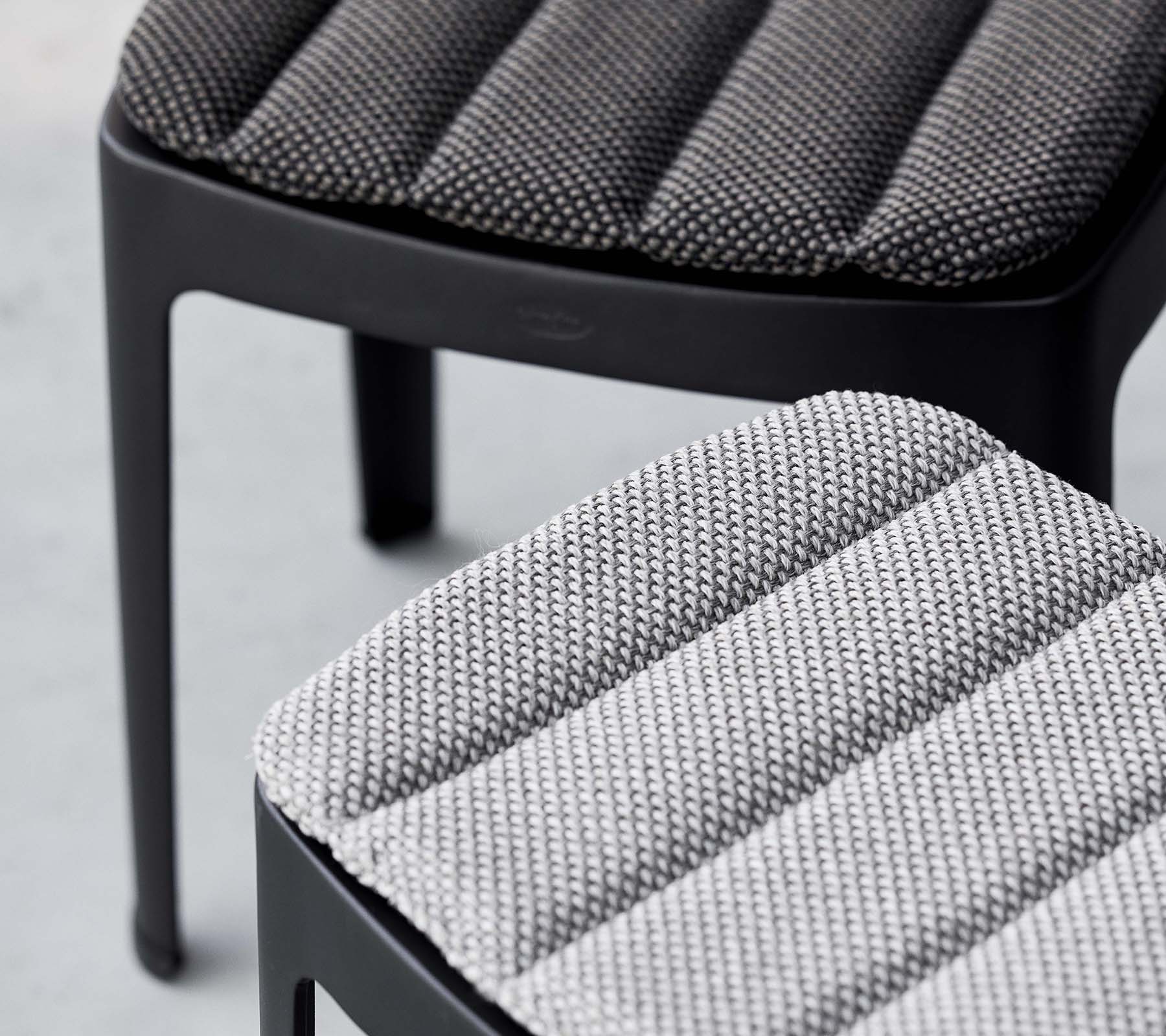 Zwei stilvolle Hocker mit strukturierter Polsterung in kontrastierenden Grautönen, die ein modernes Design mit schlanken Linien präsentieren.