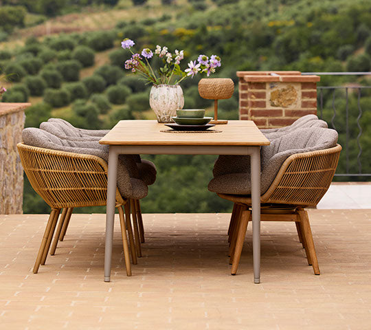Stilvolles Esssetup mit einem Core Esstisch und Stay-Stühlen, geschmückt mit einer Vase voller Blumen, die eine einladende Atmosphäre schafft.