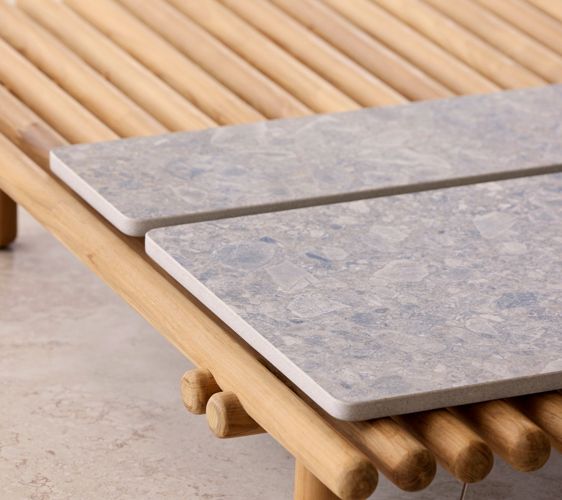 Ein Couchtisch mit einem Stabdesign und zwei Steinplatten als Tischplatten.