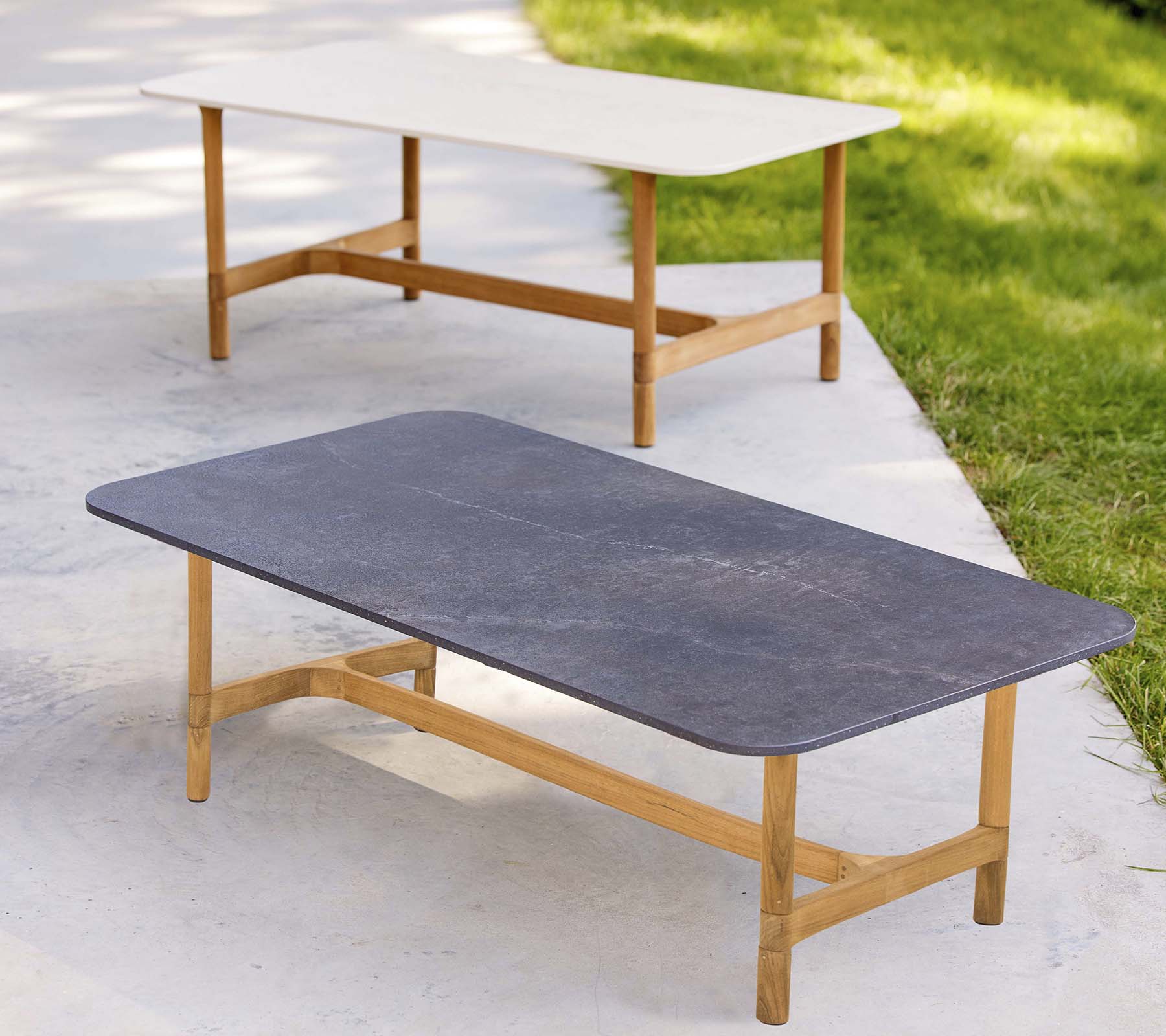 Zwei stilvolle Couchtische mit Holzrahmen und kontrastierenden Tischplattenfarben, die ein modernes, minimalistisches Design aufweisen.