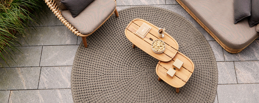 A cozy seating arrangement featuring a woven rug and a wooden coffee table, accented with decorative items. Perfect for relaxation.