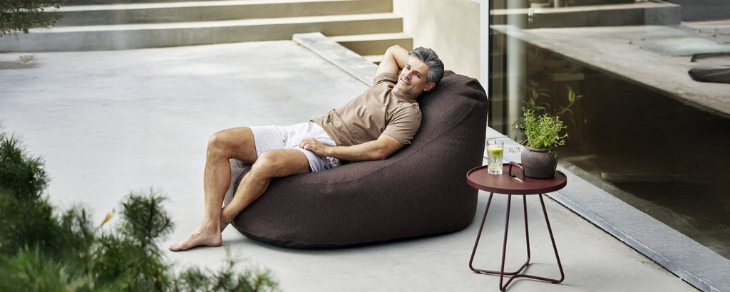 Brauner Sitzsack und Beistelltisch in einem modernen Lounge-Setting.