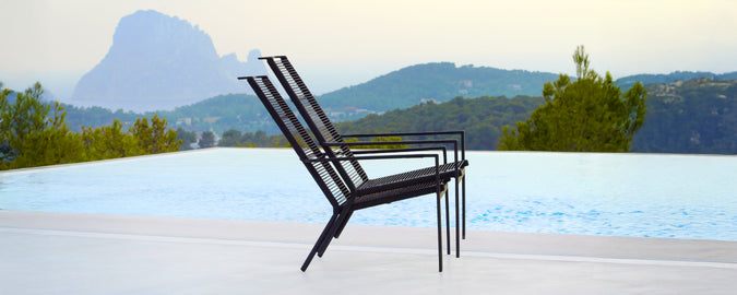 Moderne schwarze Stühle in der Nähe eines Pools mit einer malerischen Kulisse.