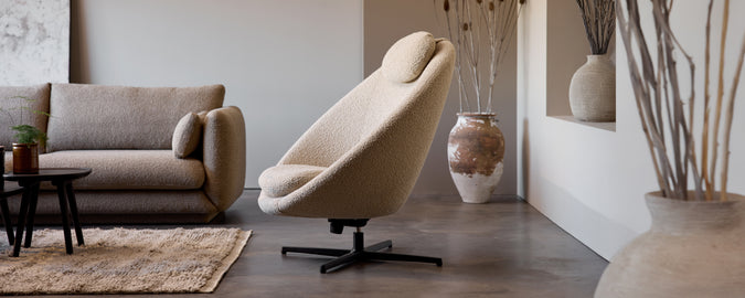 Beiger Schreibtischstuhl und gra sofa in einer modernen Lounge-Umgebung.