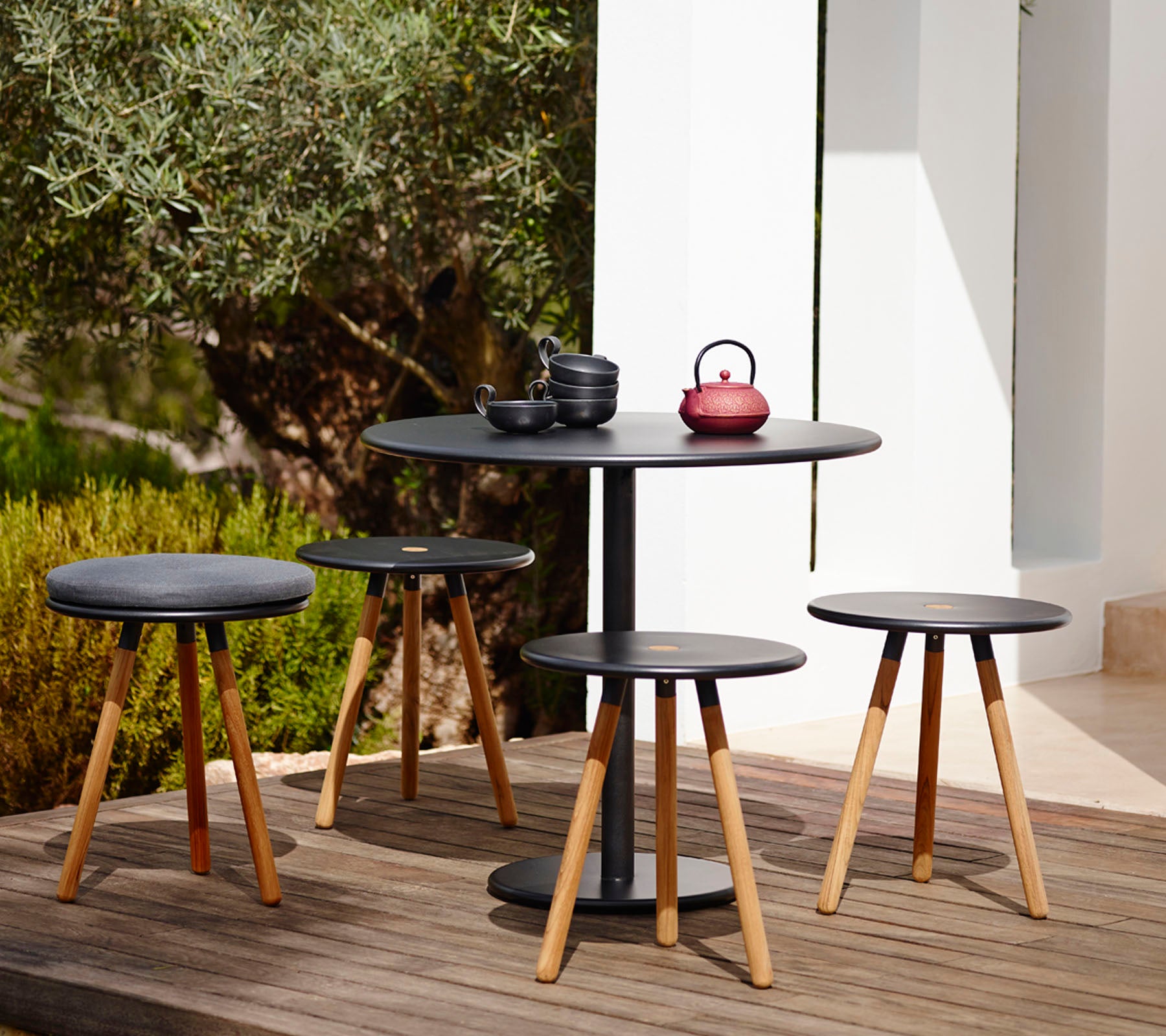 Modernes schwarzes Tisch- und Stuhlset in einer Outdoor-Gartenumgebung.