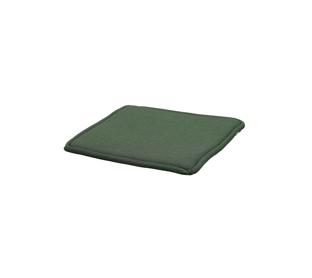 Hellgrünes Kissen auf einer flachen Oberfläche platziert.