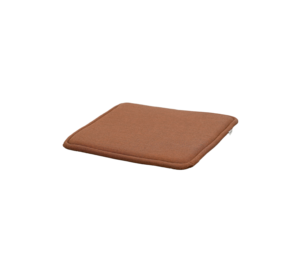 Wüstenrote Kissen mit quadratischer Form und subtiler Dicke.