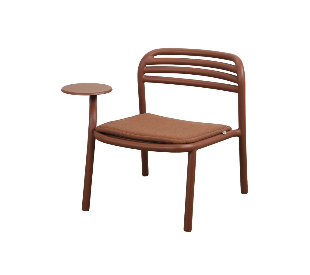 Moderne Stuhl in Wüstrot mit einem kleinen Beistelltisch.