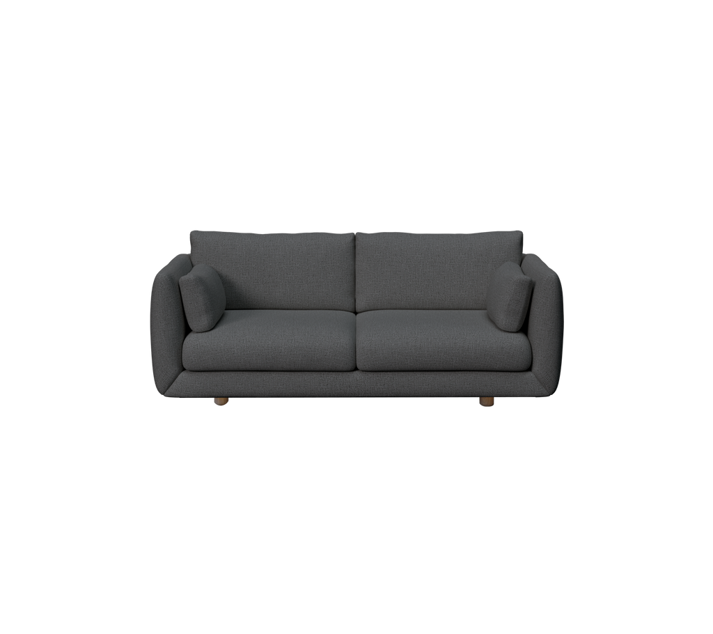 Dunkelgrüne Couch mit zwei Kissen in einem modernen Lounge-Ambiente.