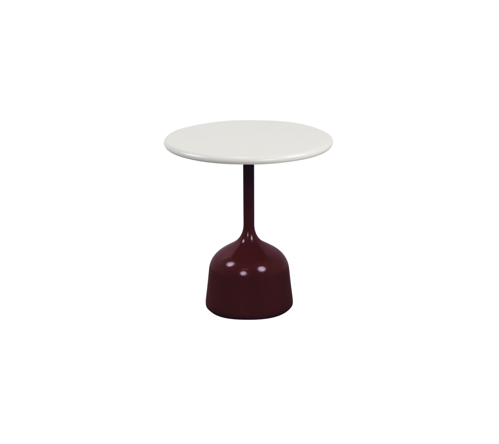 Modernes burgunderfarbenes Tisch mit einer weißen Tischplatte in einer Lounge-Umgebung.