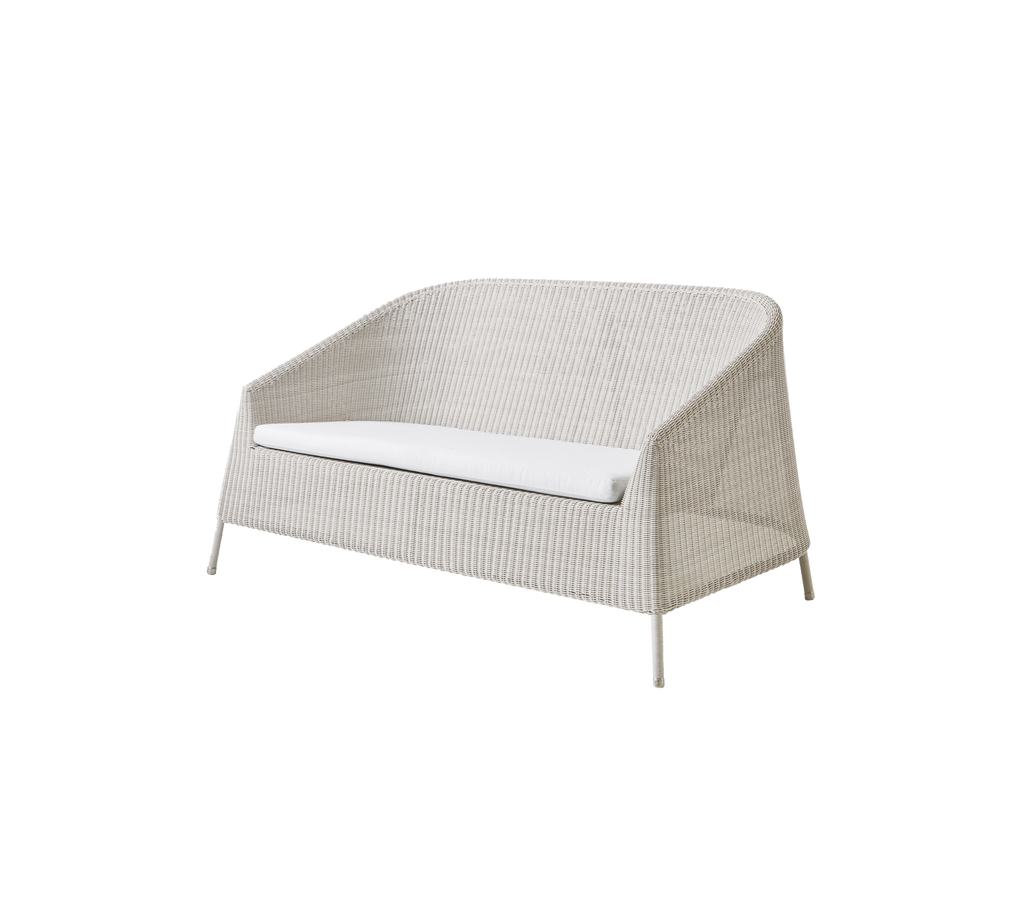 Moderne sandfarbene Loveseat mit einem weißen Kissen in einem minimalistischen Design.