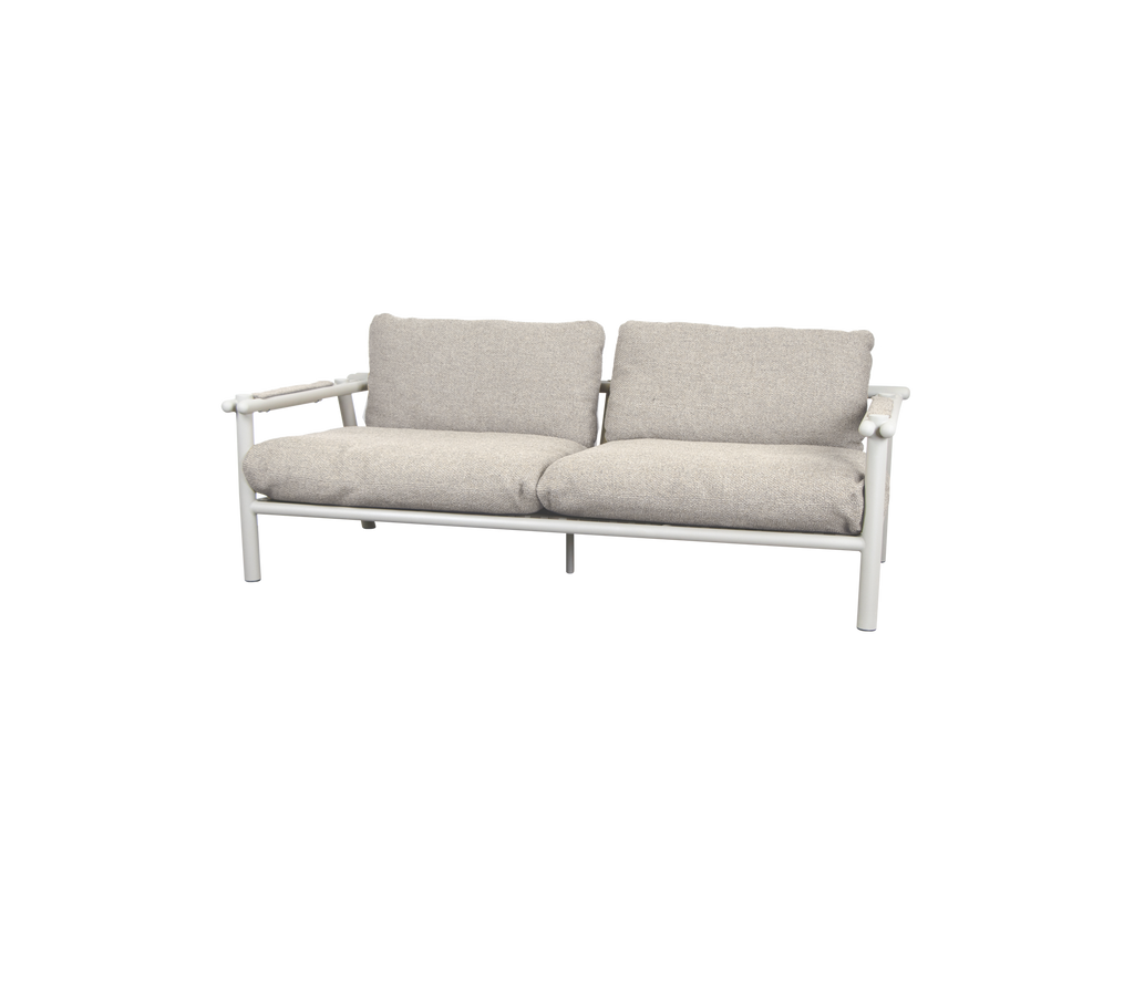 Moderne Sofa mit sandfarbenen Kissen und weißem Rahmen.