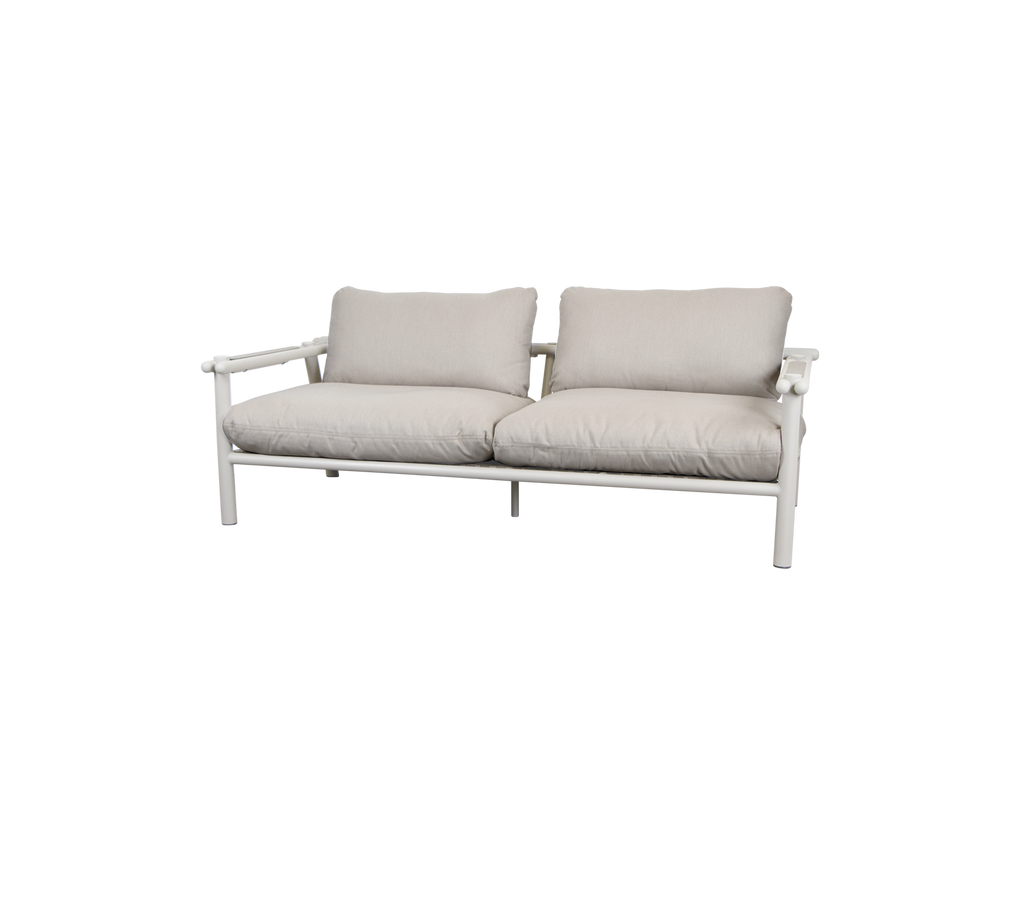 Moderne Sofa mit sandfarbenen Kissen und einem hellen Rahmen.