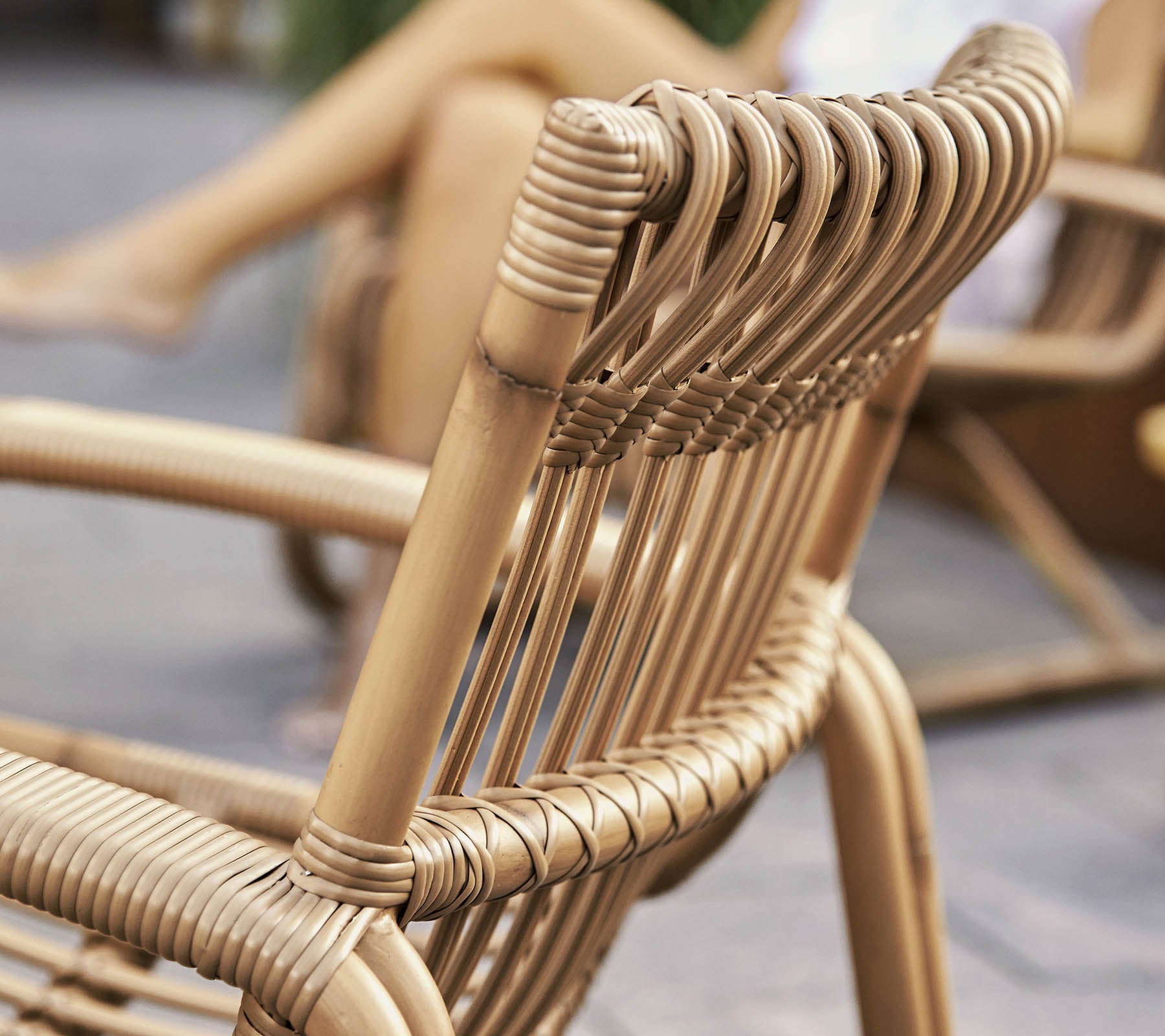 Nahaufnahme eines stilvollen geflochtenen Stuhls mit modernem Design, das detaillierte Handwerkskunst und natürliche Materialien präsentiert.