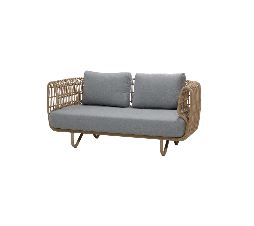 Natürliche Sofa mit grauen Kissen in einer modernen Lounge-Umgebung.