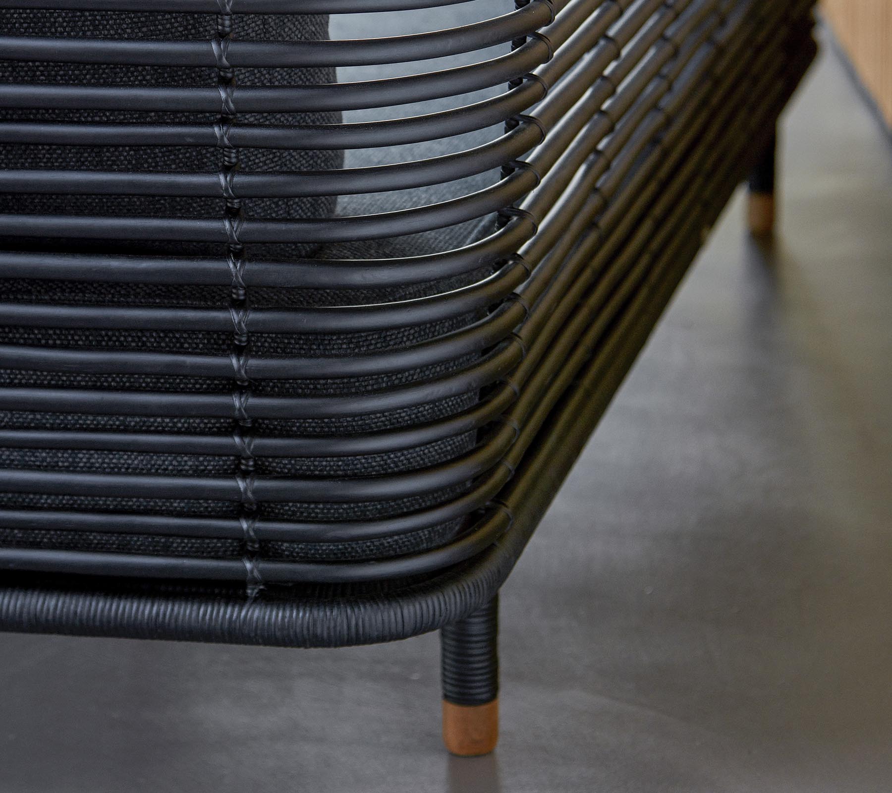 Stilvolle schwarze geflochtene Möbel mit geschwungenen Linien und Holzakzenten, die eine moderne Designästhetik präsentieren. Eine perfekte Ergänzung für jeden Raum.