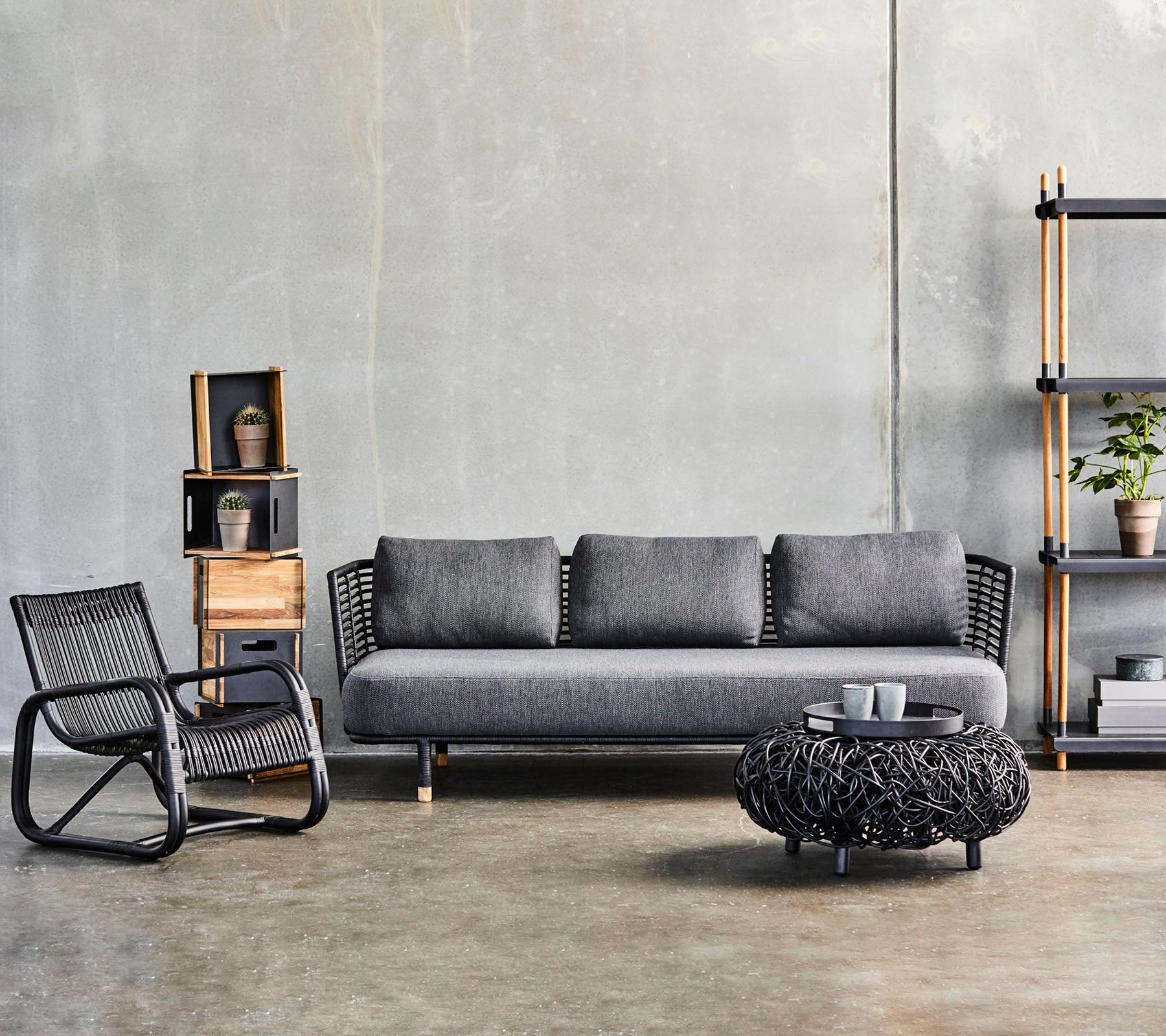 Moderne Wohnzimmeranordnung mit einem eleganten Sofa, einem strukturierten Couchtisch und einem stilvollen Akzentstuhl, ergänzt durch dekorative Regale.