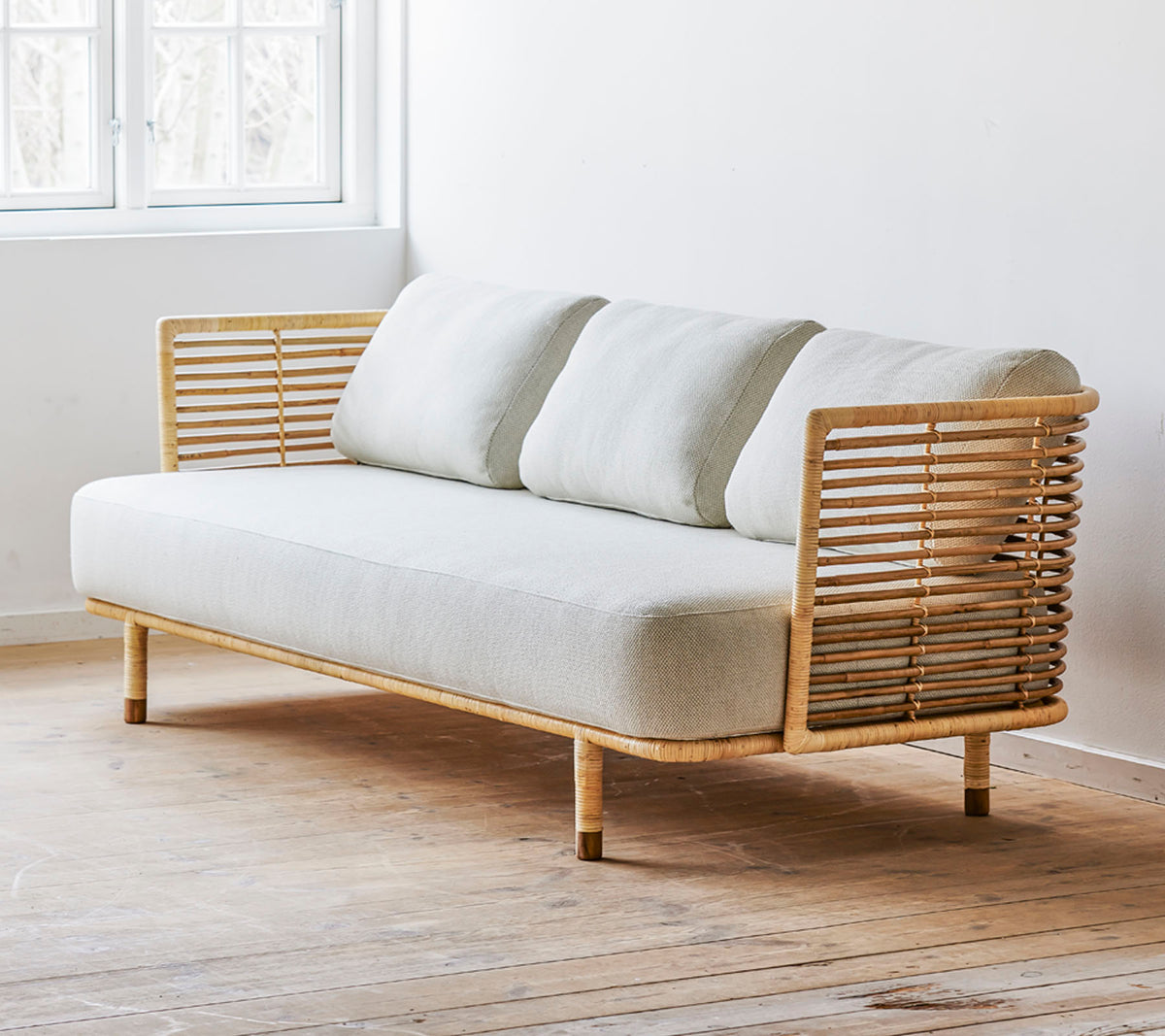 Ein modernes Sofa mit einem eleganten Design, das über einen hellen Stoffbezug und stilvolle Holzakzente verfügt. Perfekt für zeitgemäße Räume.