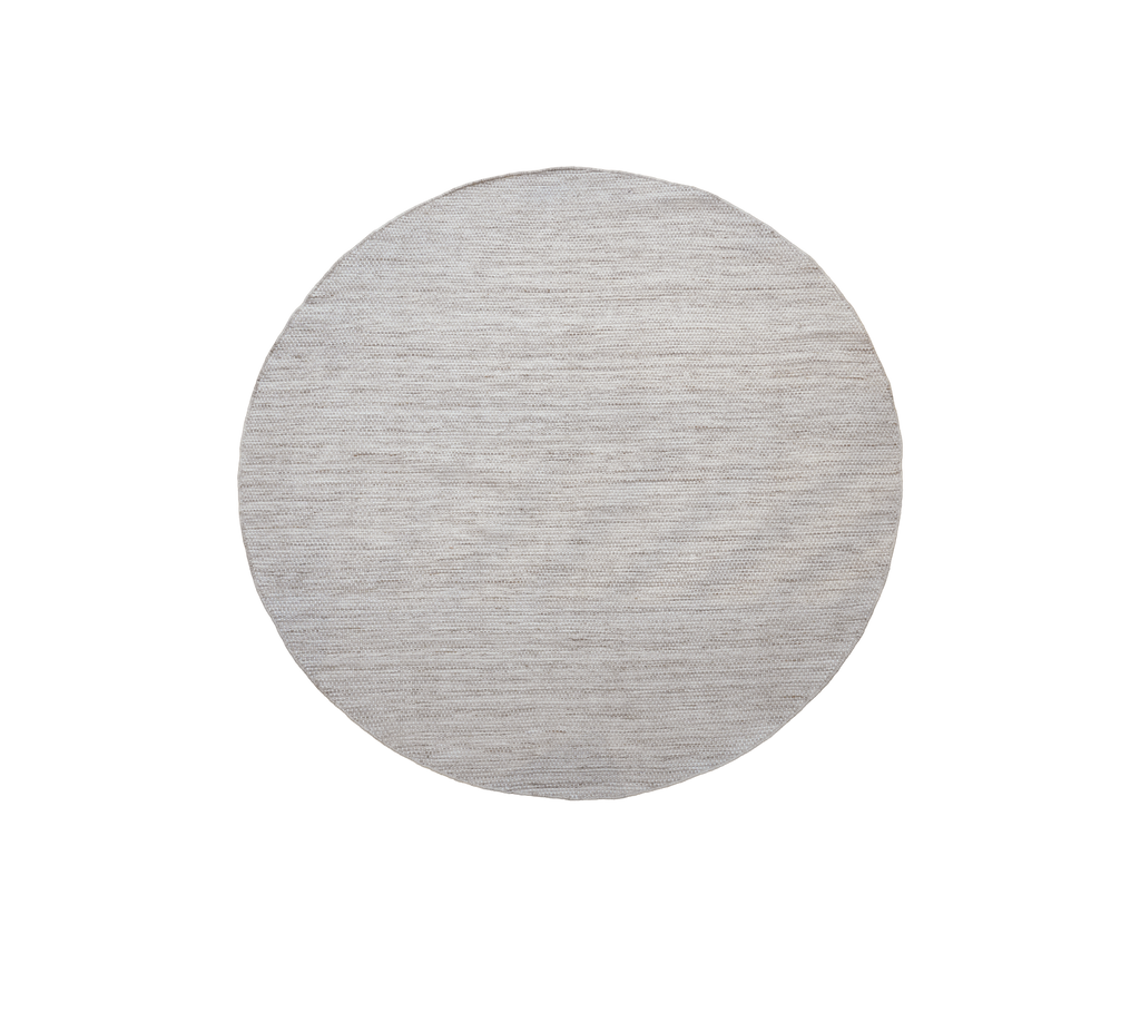 Runder Tisch in einer sandfarbenen Mehrfarbenausführung.