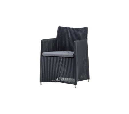 Stilvoller schwarzer geflochtener Stuhl mit einem weichen grauen Kissen, perfekt zur Entspannung in jeder Umgebung.