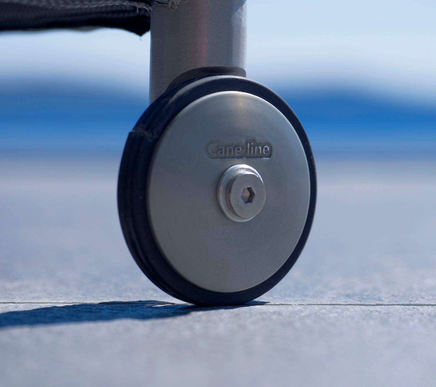 Nahaufnahme eines strapazierfähigen Rollenrades mit Metallfinish und einem Logo, das für einfache Mobilität und Stabilität auf verschiedenen Oberflächen ausgelegt ist.