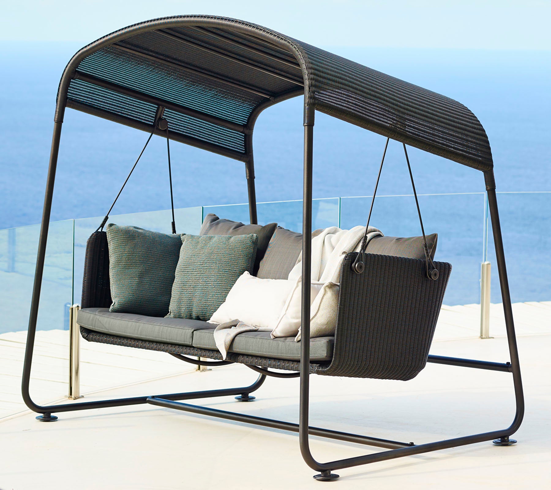 Stilvolle Schaukelstuhl mit modernem Design, ausgestattet mit plüschigen Kissen und einem schlanken Rahmen, perfekt zum Entspannen.