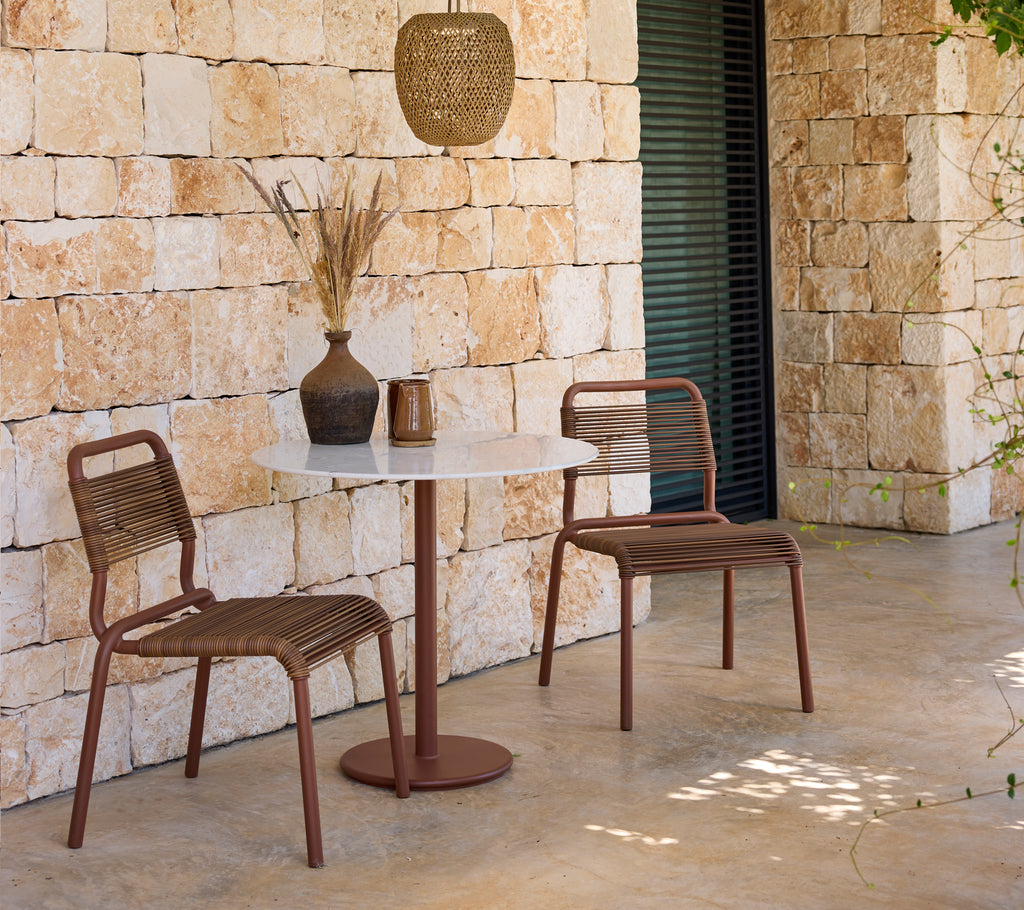 Moderne Lounge-Setup mit braunen Stühlen und einem weißen Tisch.