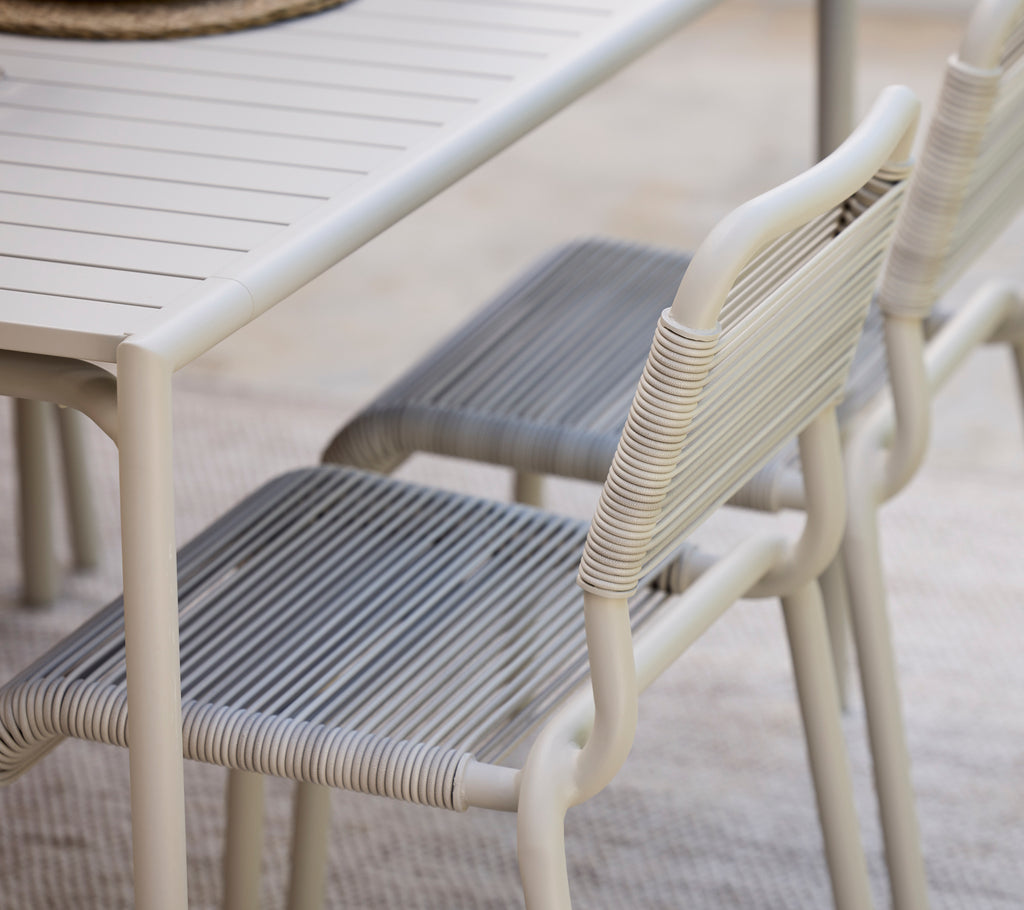 Moderner Esstisch mit weißer Oberfläche und grauen Stühlen.