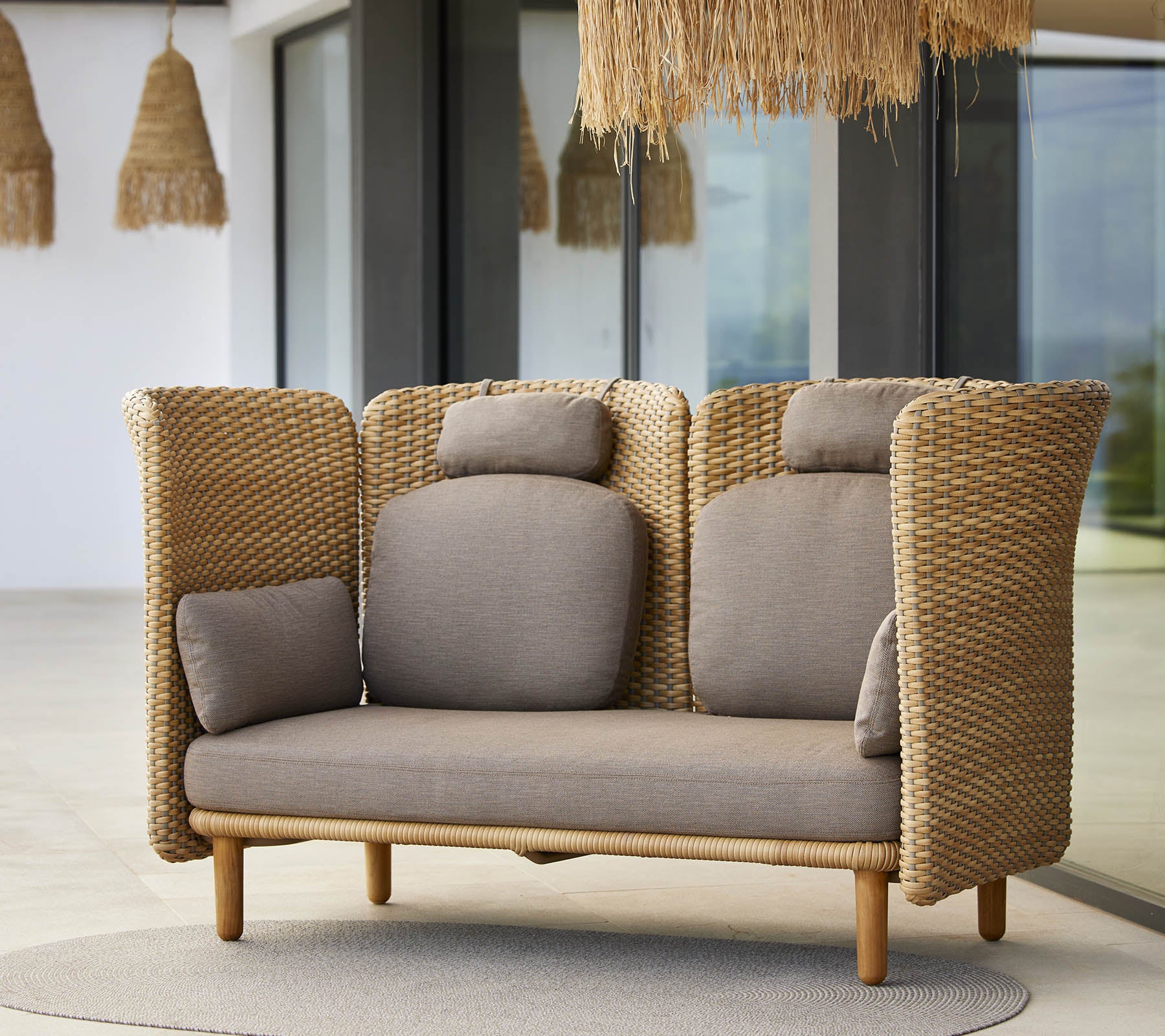Ein stilvolles Lounge-Sofa mit gewebten Seiten und weichen Kissen, entworfen für Komfort und Entspannung. Ideal für moderne Räume.