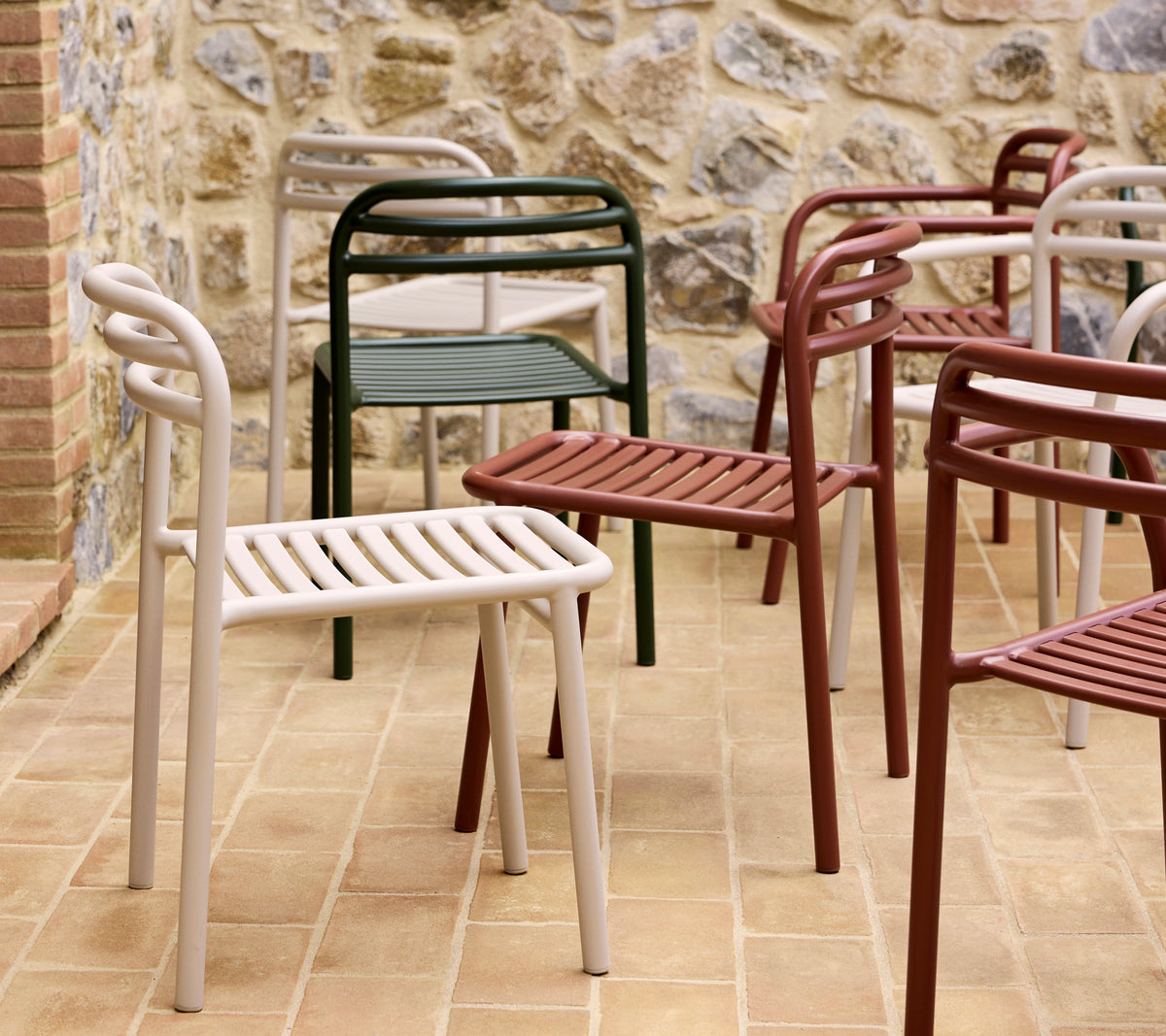 Eine Sammlung bunter Bliss-Stühle in verschiedenen Farbtönen, die ein modernes, minimalistisches Design mit lamellenartigen Sitzen und geschwungenen Rückenlehnen zeigt.