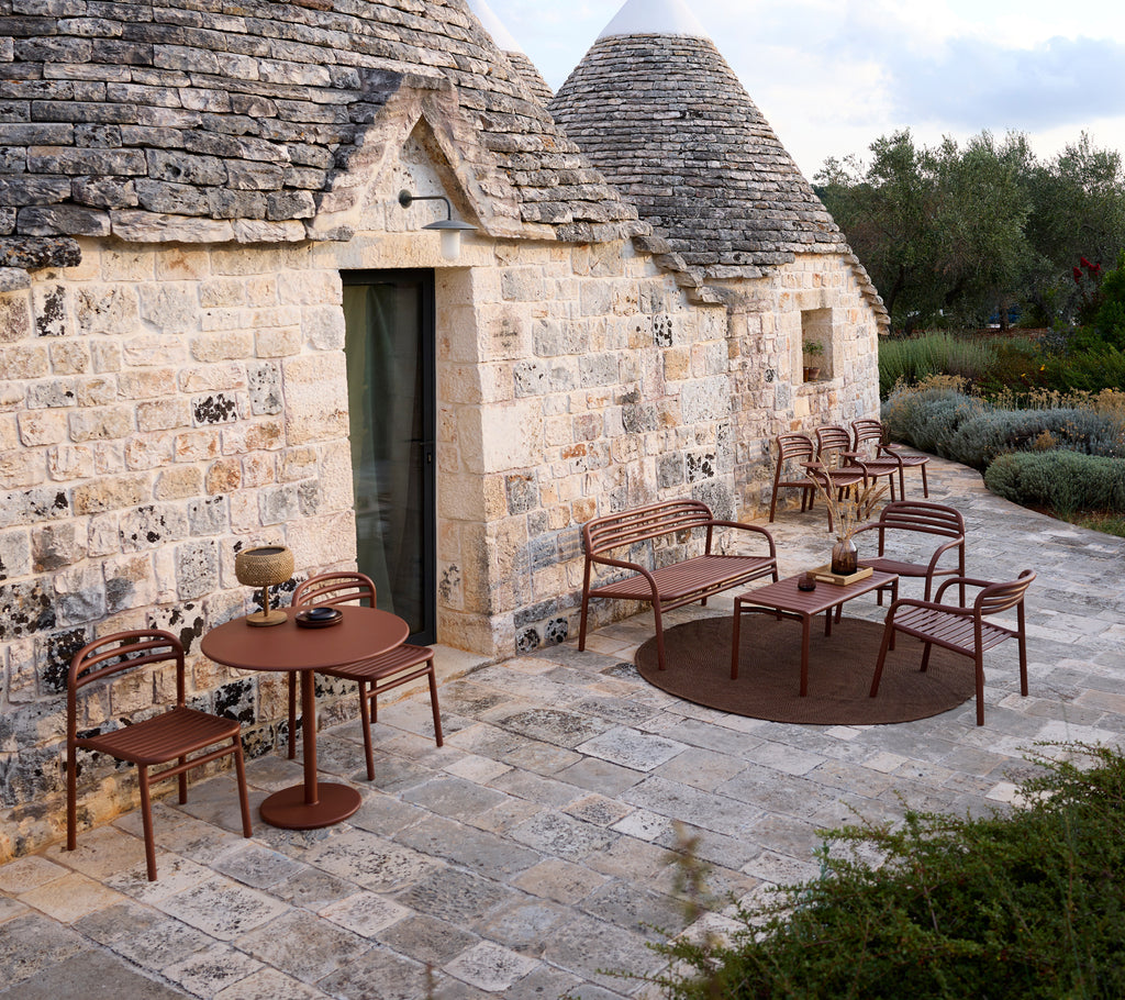 Außenbereich mit einem braunen Tisch und Stühlen in modernem Design.