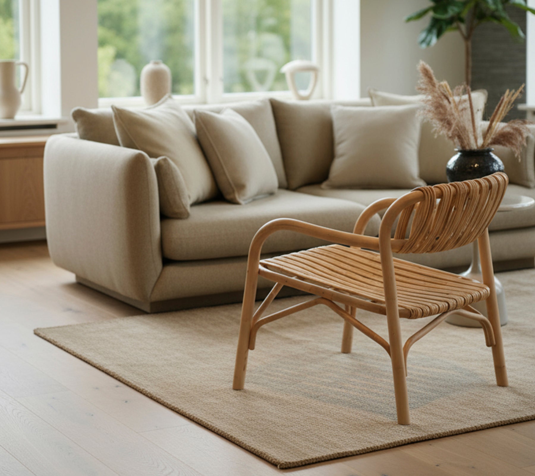 Moderne Wohnzimmer mit einem beigen Sofa und einem geflochtenen Stuhl.