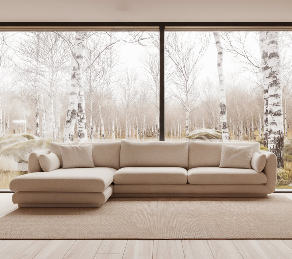 Beige moderne Sofa in einem hellen Lounge-Ambiente mit großen Fenstern.