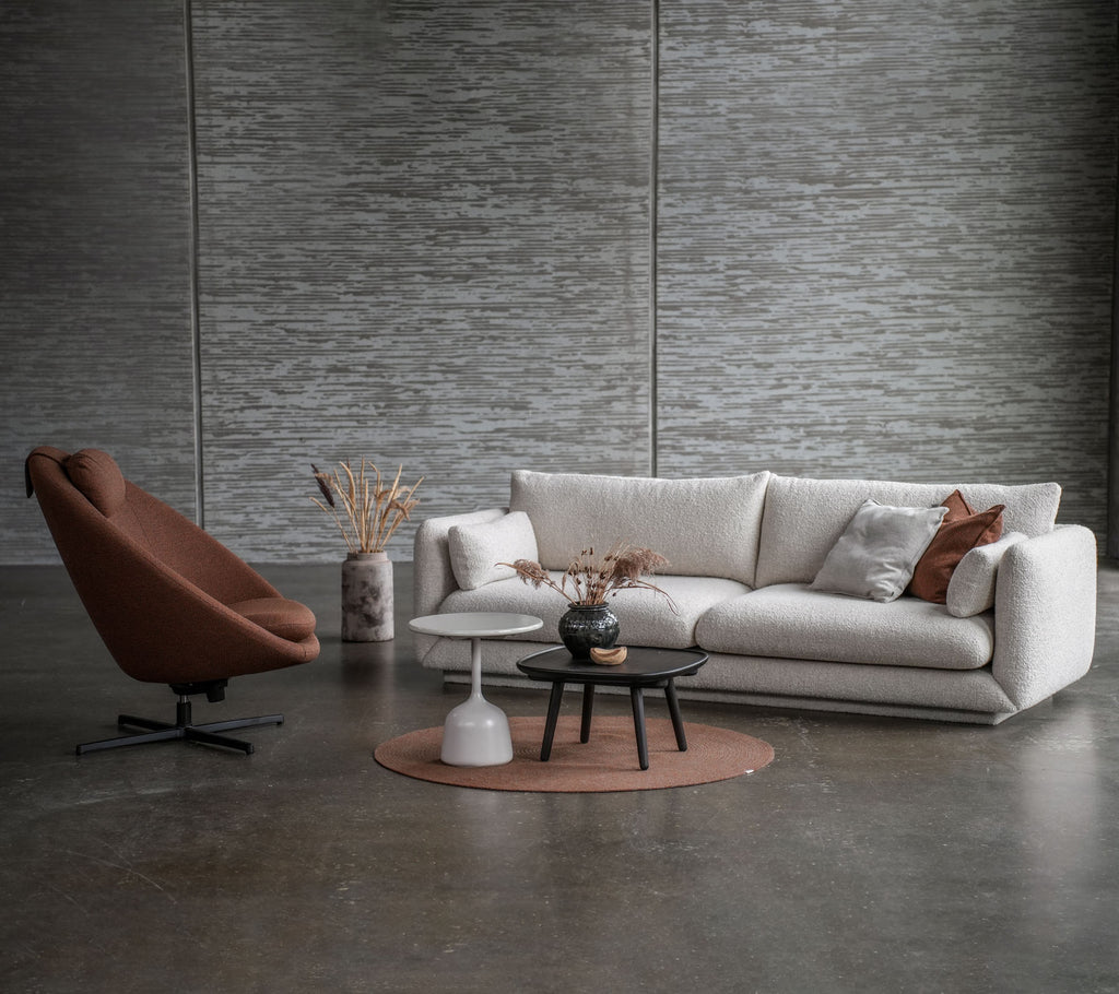 Modern seating arrangement featuring a Bloom sofa with teak legs, a stylish Pace chair, and a glazed coffee table on a round rug.