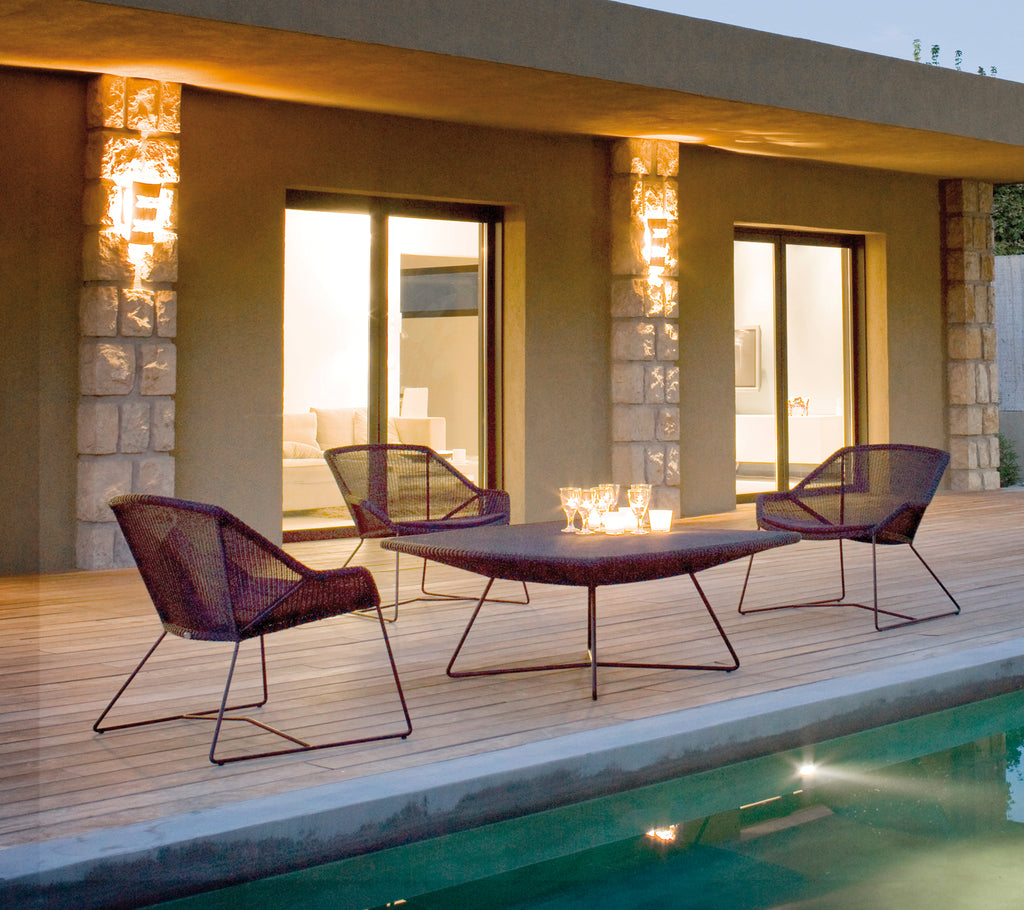 Moderne Außenbereich mit lila Liegestühlen und einem passenden Tisch neben einem Pool.