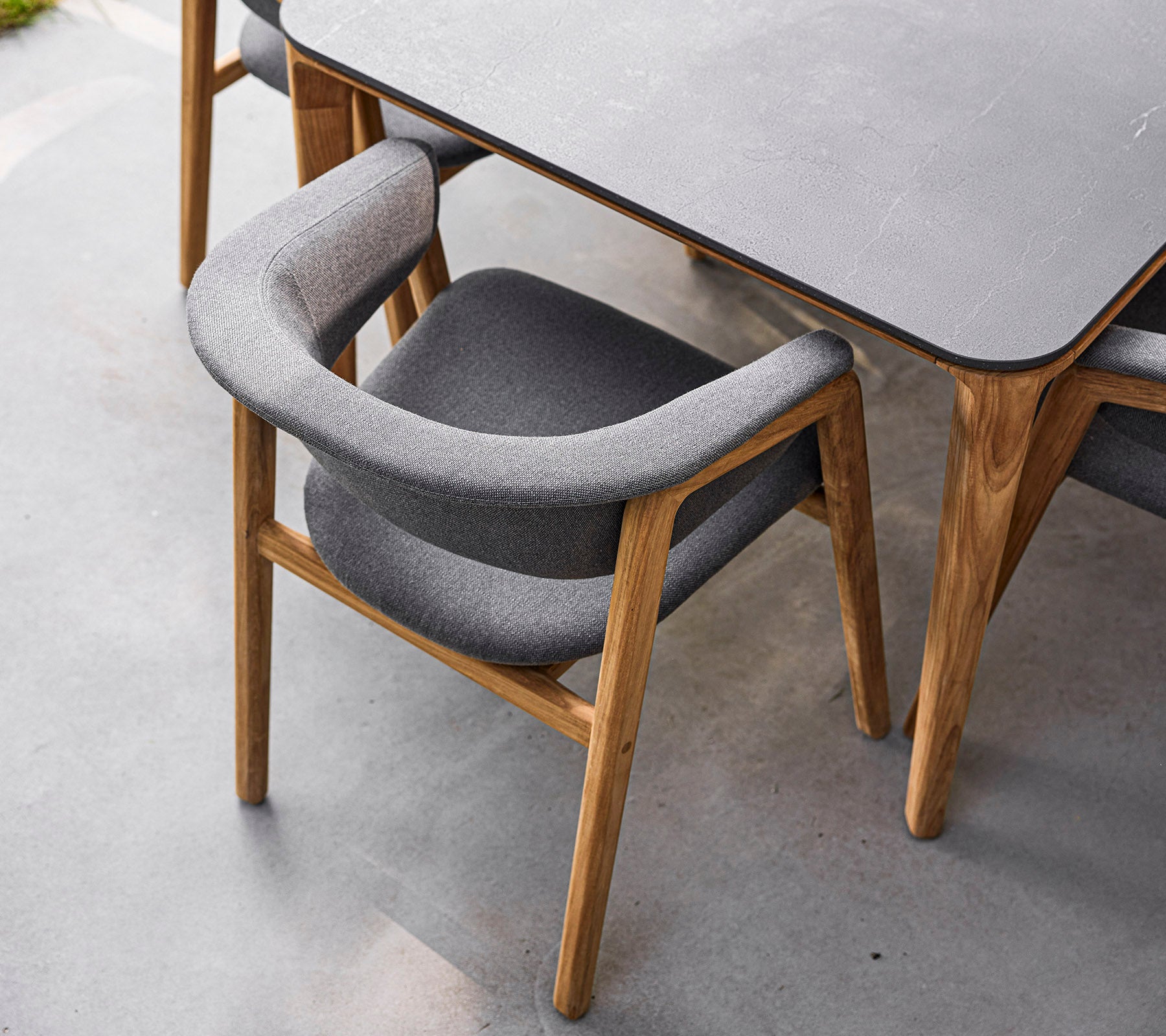 Stylischer Stuhl mit Holzrahmen und weichem grauen Bezug, entworfen für Komfort und Eleganz. Perfekt für moderne Essbereiche.
