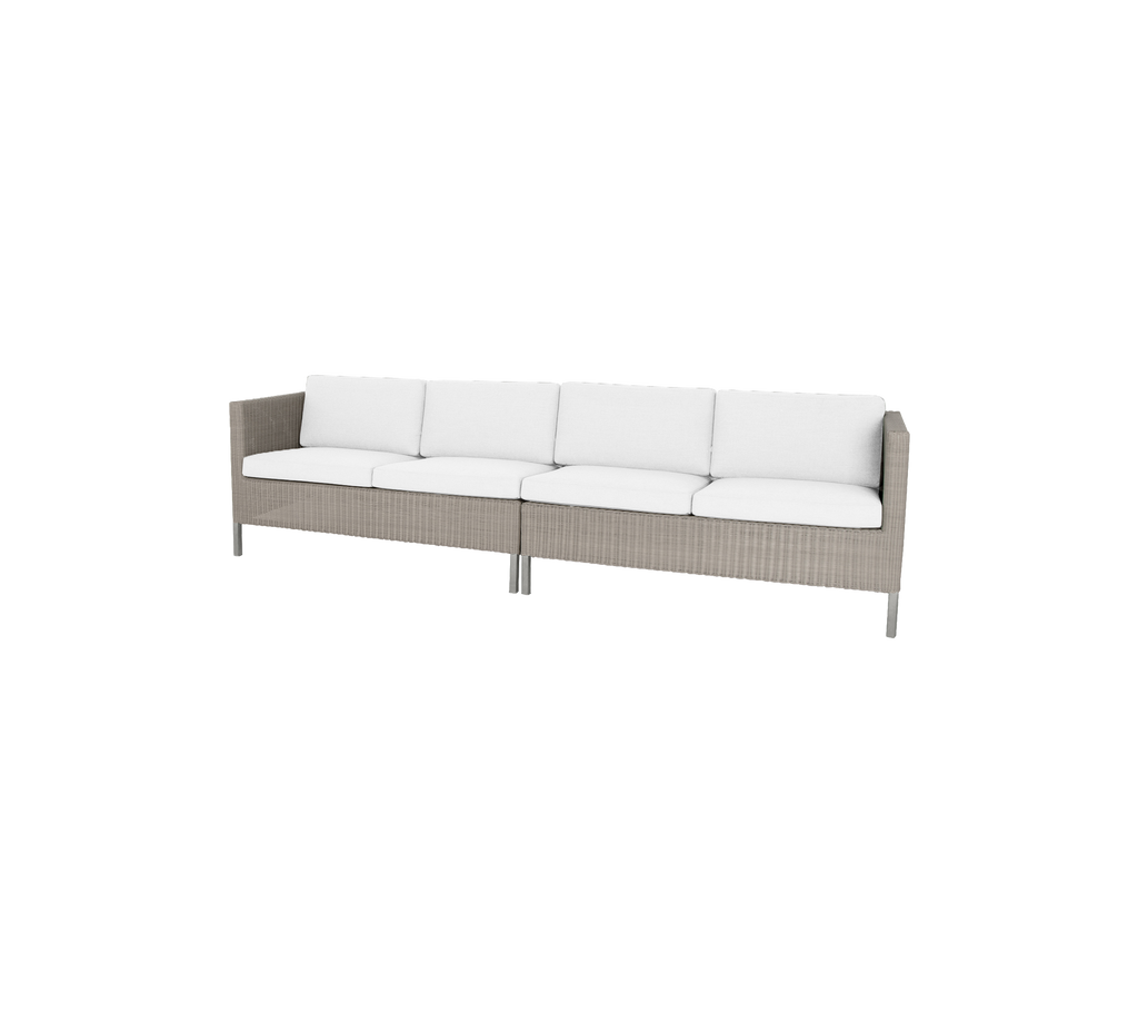 Stilvolle Sofa mit einem geflochtenen Gestell und plüschigen weißen Kissen, perfekt zur Verschönerung eines Essbereichs.