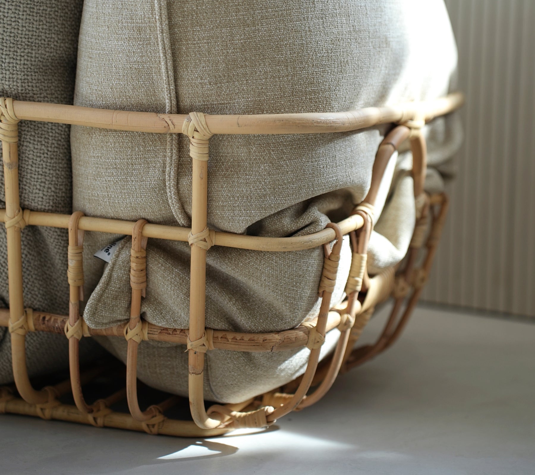 Beige Kissen in einem geflochtenen Korb, das eine bohemian Ästhetik zeigt.