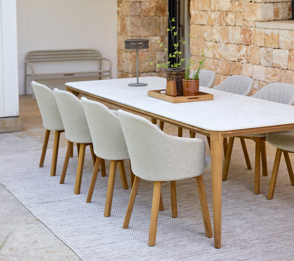 Moderne Essbereich mit einem weißen Tisch und beigen Stühlen.