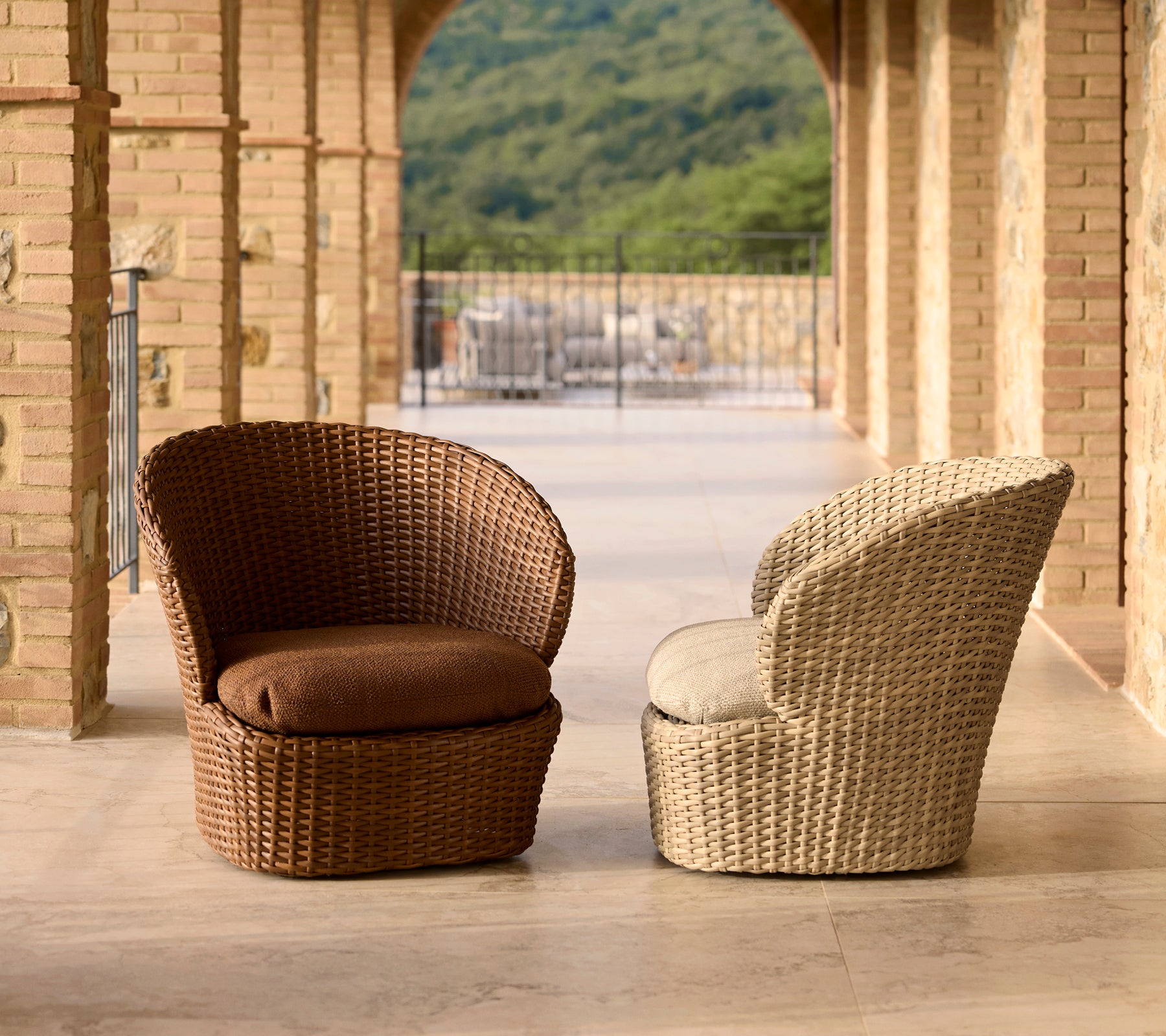 Zwei stilvolle Lounge-Stühle für die Küste aus braunem und cremefarbenem Korbgeflecht, ausgestattet mit bequemen Kissen und einem modernen Design.