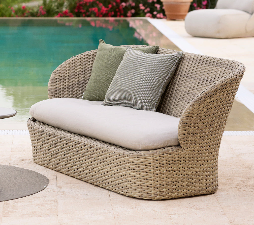 Küsten-Lounge-Sofa mit weichen Kissen, ausgestattet mit einem gewebten Design in sandiger Farbe, perfekt zum Entspannen am Pool.