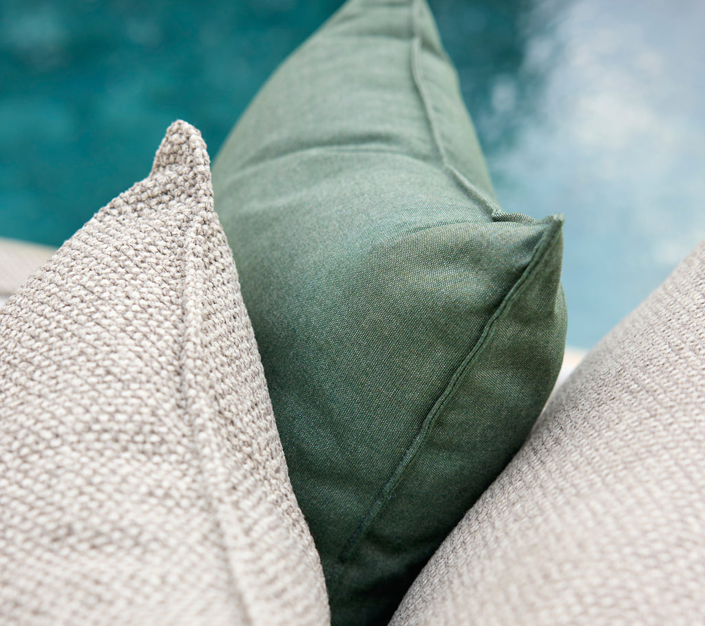 Grüne und graue Kissen zusammen angeordnet.