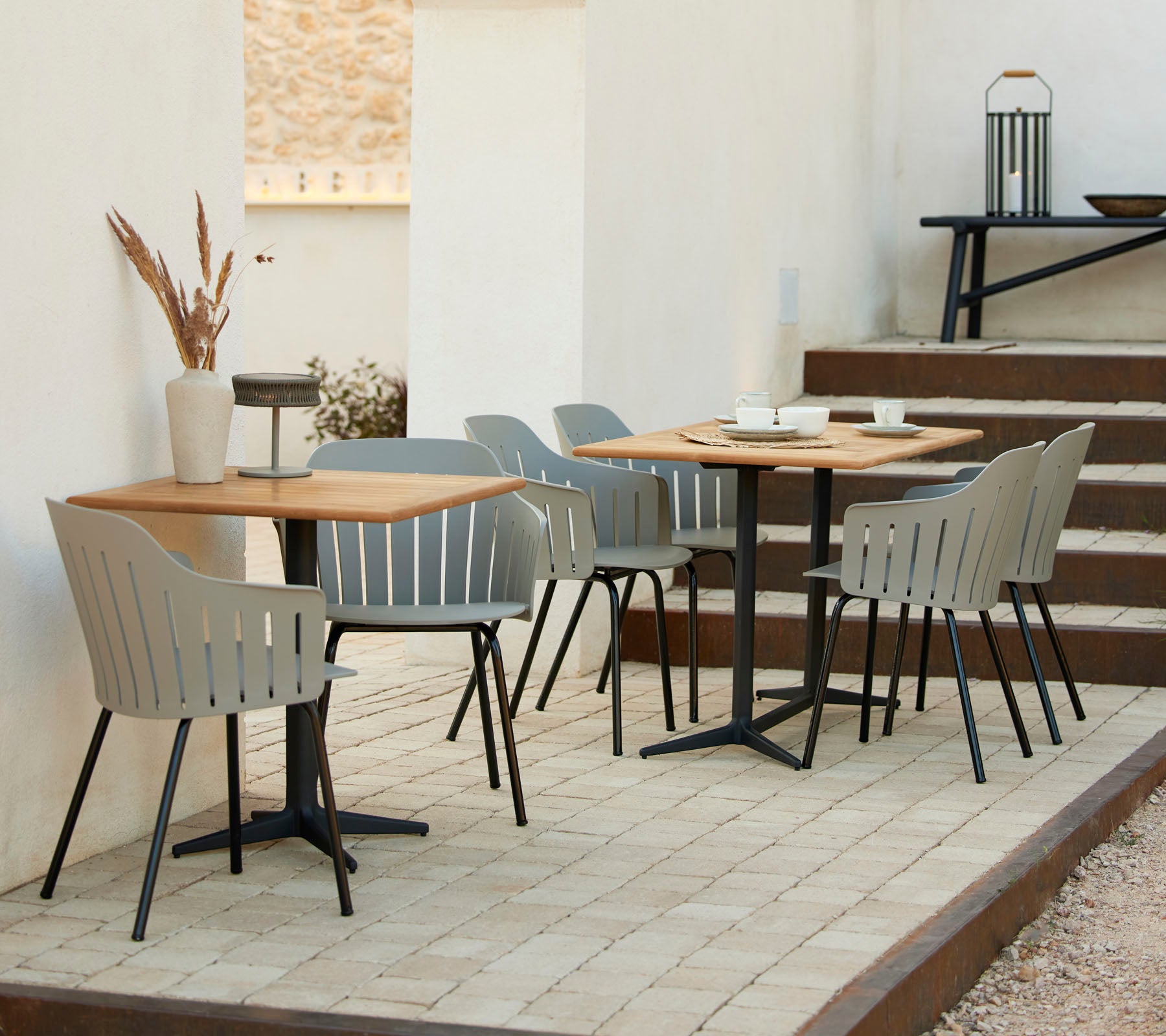 Ein stilvolles Café-Ambiente mit Holztischen, grauen Stühlen und dekorativen Akzenten, ideal für ungezwungene Zusammenkünfte und Entspannung.
