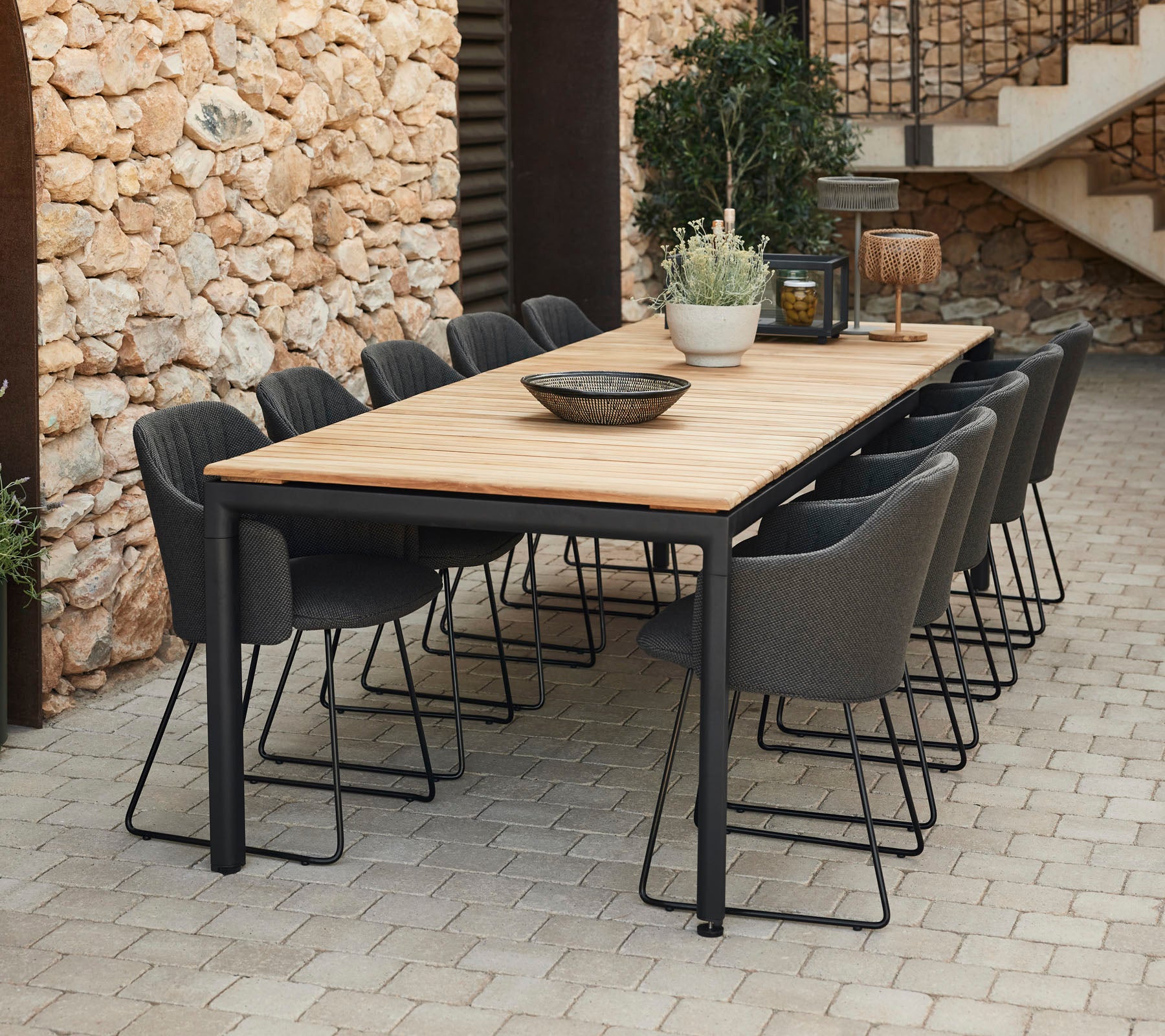 Eleganter Esstisch mit einer Holzplatte und schwarzen Metallbeinen, umgeben von grauen Stühlen, perfekt für Zusammenkünfte.